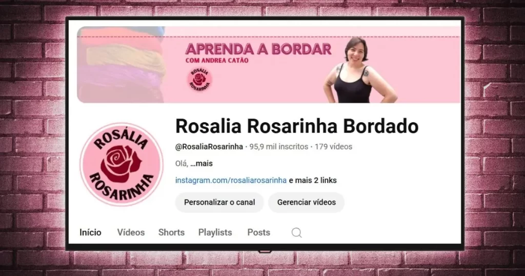 capa do canal de bordado livre "rosália rosarinha bordado" no youtube emoldurada numa tv digital pendurada em uma parede de tijolos aparentes, que ilustra uma chamada para o canal no site agulhas da resistência subvertendo linhas e pontos