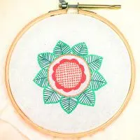 bordado à mão de flor ao centro de uma mandala feita em ponto caseado 3D, ponto treliça, ponto mosca e ponto corrente. bordado em algodão em moldura de bastidor de madeira