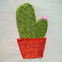 cacto dentro de um vaso bordado à mão sobre tecido de algodão