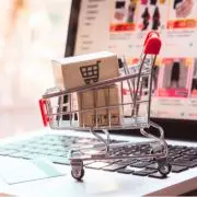 carrinho de compras com caixas dentro sobre um teclado de computador para ilustrar vendas online