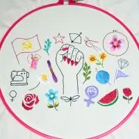 peça bordada à mão chamada "manifesto bordado" da artesã andrea catão, composta por vários símbolos políticos e das artes manuais