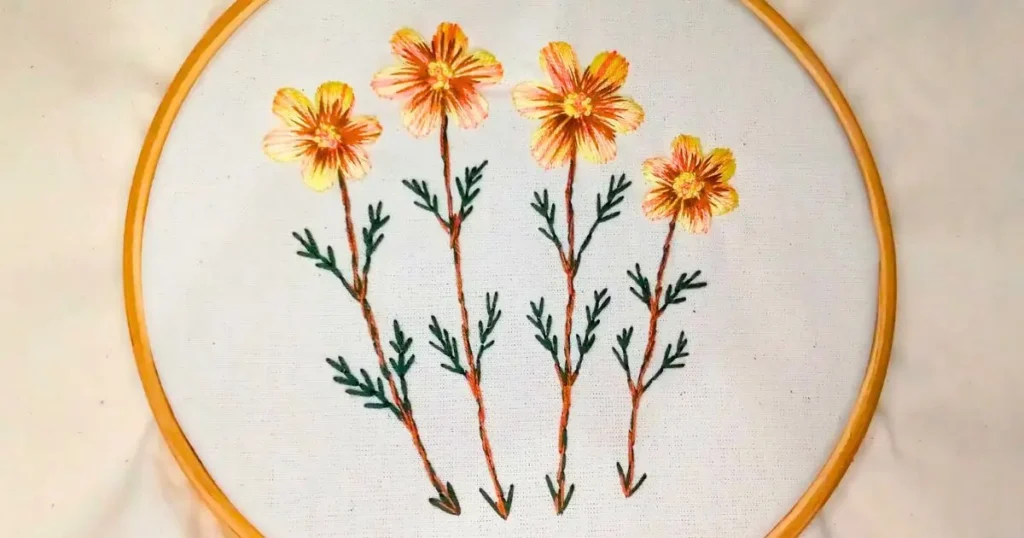 quatro flores amarelas bordadas à mão em ponto cheio. criado pela artesã andrea catão para o canal rosália rosarinha