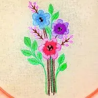arranjo floral com flores e folhas bordado à mão. a peça é da artesã andrea catão para o canal rosália rosarinha bordado