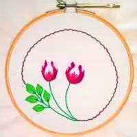 bordado à mão de arranjo floral de tulipas com ponto cheio em tecido de algodão em moldura de bastidor. trabalho da artesã andrea catão para o canal rosália rosarinha bordado